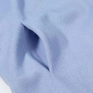 Nahaufnahme der Seitentasche eines hellblauen Wollmantels mit feinen Nähten und Textur
