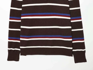 Detail of striped knit sweater hem and cuffs in retro brown with multi-color blocks