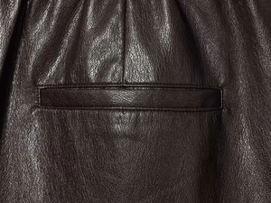 Détail du short en similicuir marron foncé avec poche passepoilée et taille élastique