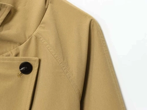 Detail of khaki jacket showing high-density fabric, black resin buttons and diagonal stitching