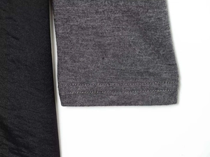Detailed macro view of the double-stitched hem on a black and grey velvet lace dress
