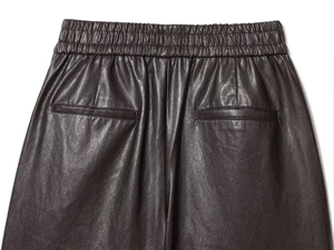 Détail de la taille élastique et des coutures sur un short en similicuir marron foncé