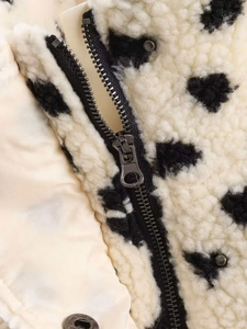 Détail de la veste en polaire à pois avec fermeture éclair en métal et texture pelucheuse