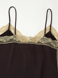 Gros plan du caraco en satin noir avec bordure en dentelle florale beige au décolleté
