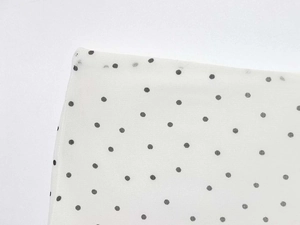 Close-up of white polka dot chiffon fabric showing the lightweight material and dot print