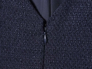 Detail of dark blue tweed dress featuring V-neckline and high-quality invisible zipper