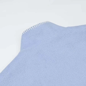 Detail aus babyblauem Wollstoff mit dekorativer weißer Whipstitch-Kantenverarbeitung