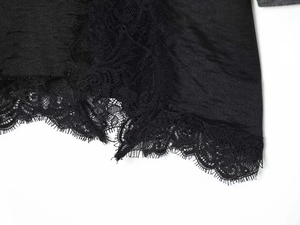 Close-up of elegant black velvet dress hem featuring delicate eyelash lace trim details