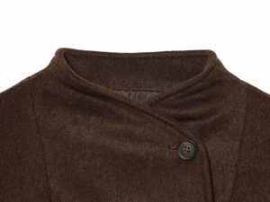 Détails du col d'un manteau en laine marron foncé avec bouton en résine et texture douce