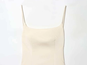 Détail d'une robe en satin ivoire à encolure carrée et fines bretelles texture soyeuse