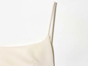 Gros plan détaillé des fines bretelles et de l'encolure d'une robe en satin crème