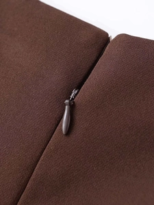 Macro detail of high-quality invisible zipper on dark brown pleated woven dress