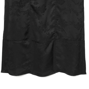 Elegant black satin dress with subtle floral jacquard texture and wavy hem detail
