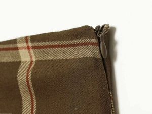 Detailed close-up of brown plaid skirt fabric with a high-quality hidden zipper closure