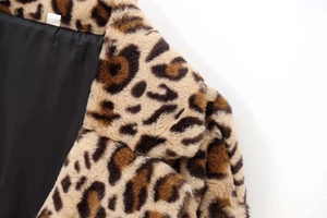 Macro shot of faux fur coat with leopard print and smooth black interior lining