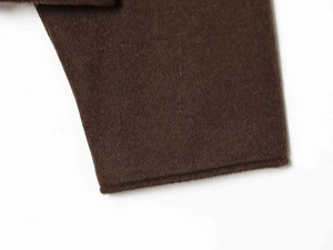 Gros plan du tissu en laine marron chocolat montrant les coutures fines et la texture