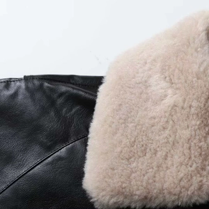 Detailed close-up of premium black leather jacket with soft beige faux fur collar