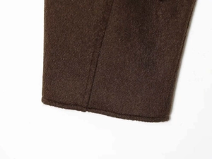 Gros plan sur la texture du tissu en laine marron chocolat avec des coutures soignées