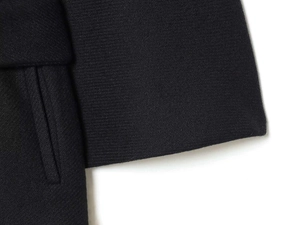 Detalle de chaqueta de lana azul marino con textura de sarga y costuras precisas