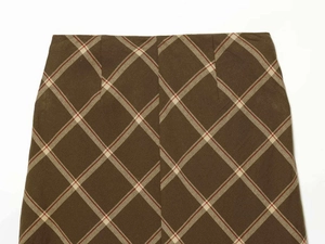 Detailed macro view of the brown plaid pattern fabric and stitching on a mini skirt