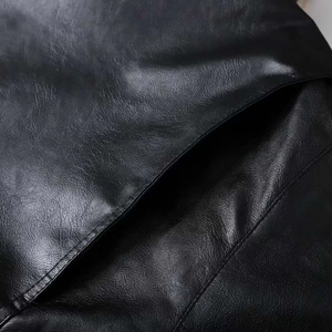Macro shot of black leather jacket side pocket featuring authentic pebble grain texture