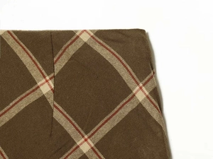 Detailed macro view of checkered fabric with red and white patterns on brown cotton
