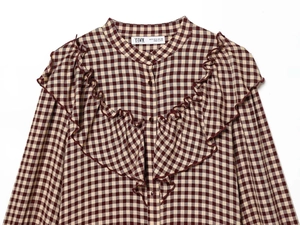 Detail of red and cream plaid long sleeve shirt with vintage ruffle layers and stand collar