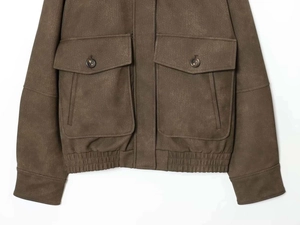 Gros plan d'une veste pilote marron vintage avec texture vieillie et grandes poches cargo