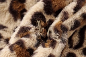 Close-up of leopard print faux fur coat featuring elastic loop closure and plush texture