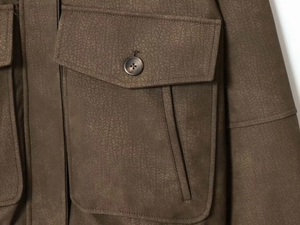 Détail de la veste vintage vert armée avec texture cuir craquelé et poche boutonnée