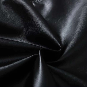 Close-up of black faux leather texture showing grain detail and soft semi-matte finish