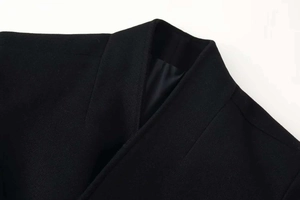 Detail shot of clean-cut lapel and high-quality black wool fabric texture on overcoat