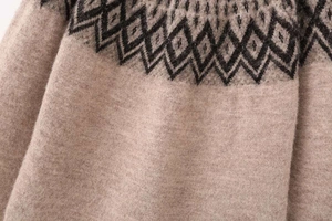 Detailed close-up of diamond pattern knitwear featuring fuzzy beige and brown wool texture