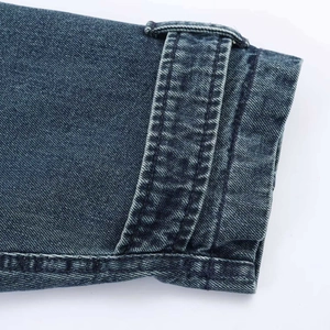 Dettaglio dei polsini in denim blu scuro che mostra le cuciture di qualità e la trama lavata