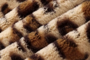Detail showing the soft texture and leopard print pattern of the faux fur coat fabric