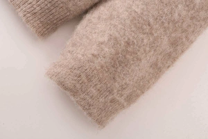 Detailed close-up of light brown diamond knit sweater showing soft plush fabric texture