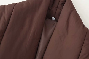 Detailed close-up of dark brown quilted cotton coat collar with premium smooth inner lining