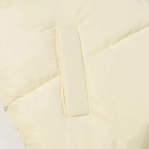 Detailed macro view of cream puffer jacket quilting and rectangle pocket patch texture