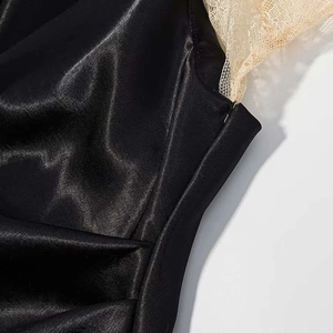 Detail of black satin dress showing silk texture, invisible zipper and gold lace trim