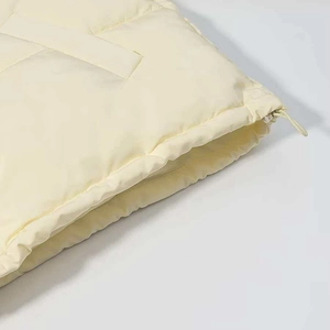 Detail of cream warm puffer jacket featuring adjustable elastic drawstring at the hemline