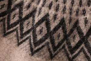 Detailed macro view of retro diamond jacquard knit fabric with soft brown wool texture