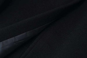 Macro shot of high-quality black wool fabric texture and silk lining detail on the coat