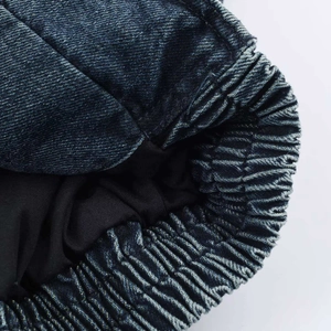 Dettaglio del polsino della giacca di jeans blu con bordo elastico e trama lavata