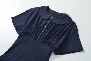 Detailed view of navy blue blouse with ruffled waist and wooden flower-shaped buttons