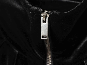 Detail eines minimalistischen Silber-Reißverschlusses an einer schwarzen Bomberjacke