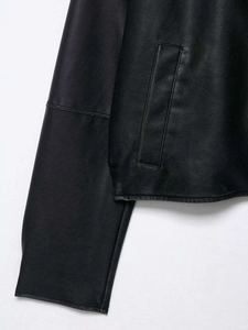 Detail view showing black PU leather texture and vertical pocket on the autumn jacket