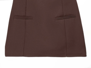 Detailed close-up of dark brown dress waist with tailored welt pockets and premium stitching