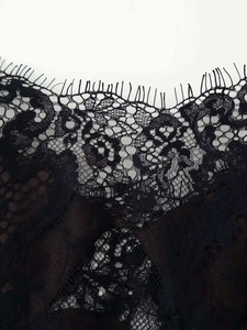 Gros plan détaillé d'une délicate dentelle noire avec motifs floraux et bords effilés