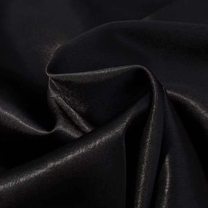 Detailed macro view of premium black satin fabric with smooth texture and elegant drape
