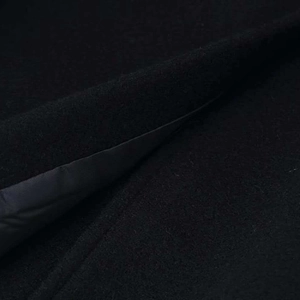 Fashionable black wool coat with stand collar and gray lining shown in macro fabric detail